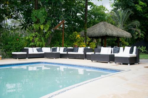 a swimming pool with a couch and a table and chairs at Hotel Vista de Olas in Santa Teresa Beach