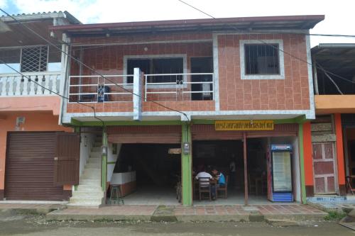 a red brick building with people sitting at a table at Hotel Clau in Nuquí