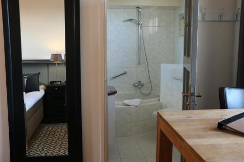 a bathroom with a shower and a bath tub at Auberge de Campveerse Toren in Veere