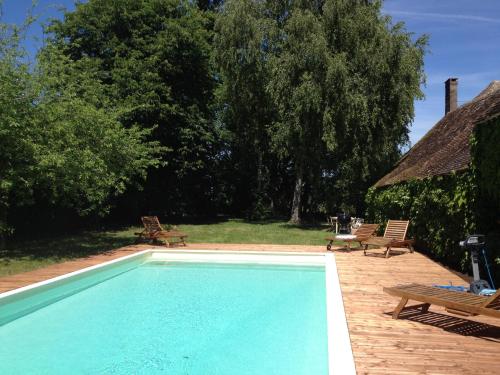 a swimming pool with two chairs and a table at Hunting Lodge - 10p - Le Mans 24hrs - private pool in Fercé-sur-Sarthe