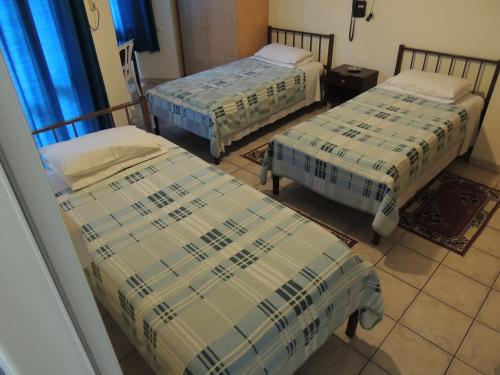a room with three beds in a room at Delphi Hotel in Nicosia