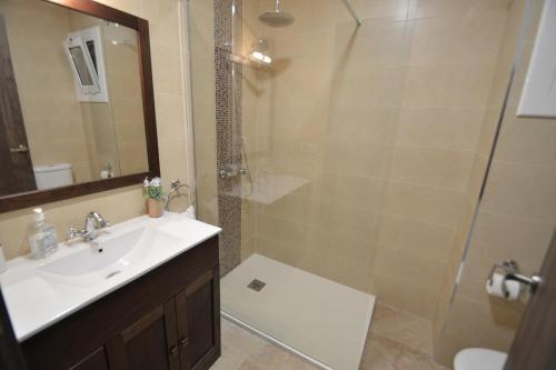 y baño con lavabo y ducha acristalada. en Apartamento Playa Capellans - Salou, en Salou