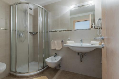 a bathroom with a sink and a shower and a toilet at Ciasa Dolomites in La Villa