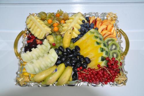 a platter of fruit and vegetables in a glass plate at Hotel & Restaurant Raueneck in Bad Saarow