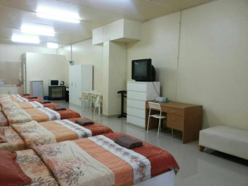 a row of beds in a room with a television at SK Muang Thong Thani in Bangkok