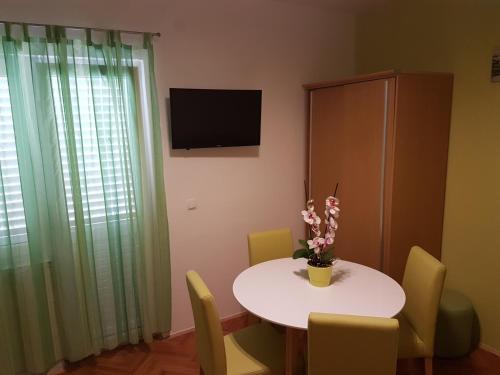 a room with a table and chairs and a television at House Villa Roza in Tučepi