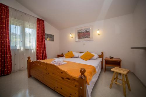 ein Schlafzimmer mit einem großen Holzbett mit gelben Kissen in der Unterkunft Apartman Bangel in Lokva Rogoznica