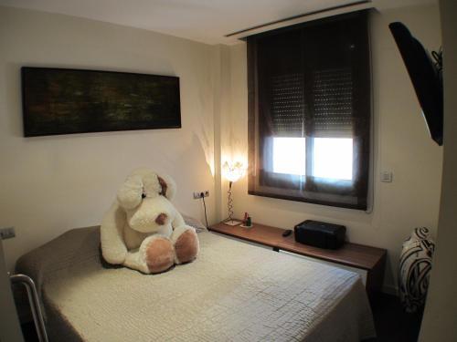 バルセロナにあるBarcelona4Seasons - Muntanerの寝室のベッドに座るテディベア