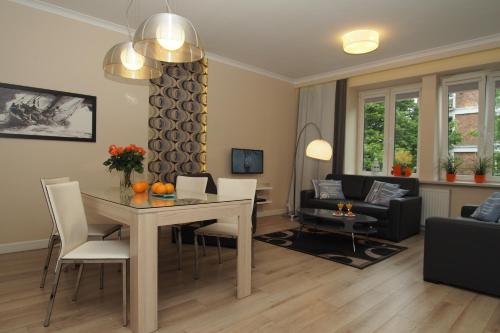 sala de estar con mesa, sillas y sofá en Grand-Tourist Center Point Apartments, en Gdansk