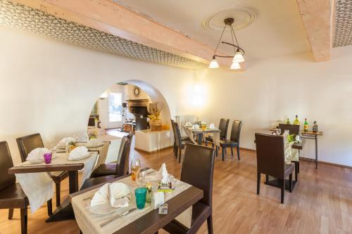 a dining room with tables and chairs in a restaurant at Logis Auberge La Cremaillere in Villandraut
