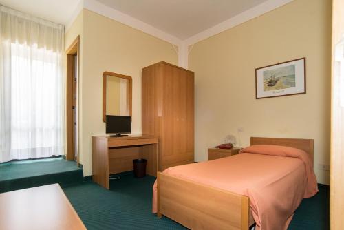 - une chambre avec un lit, un bureau et une télévision dans l'établissement Hotel Tre Castelli, à Gallicano