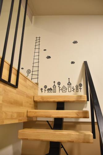 a staircase with a wall with drawings on it at TUCK Me iN in Chiang Mai