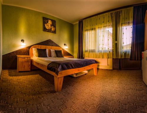 sypialnia z łóżkiem i oknem w obiekcie MarLiv Complex w mieście Tăşnad