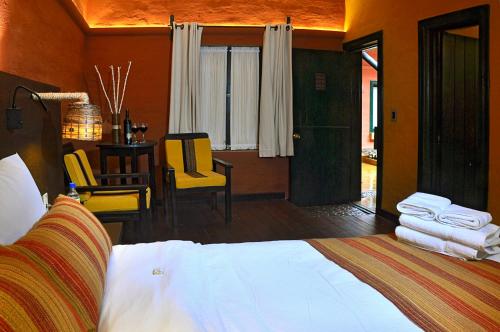 a bedroom with a bed and a table and chairs at Hotel Jardines de Uyuni in Uyuni