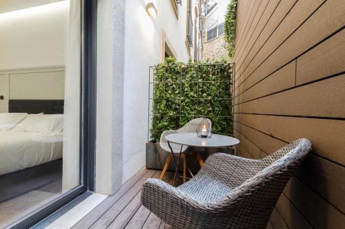 a patio with two chairs and a table on a balcony at Hotel SANSEbay in Donostia-San Sebastián
