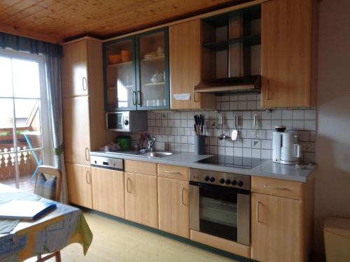 a kitchen with wooden cabinets and a stove top oven at Stroblbauernhof in Seeham