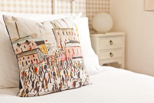 a pillow with a group of people on a bed at 3 Cambridge Villas in Ambleside