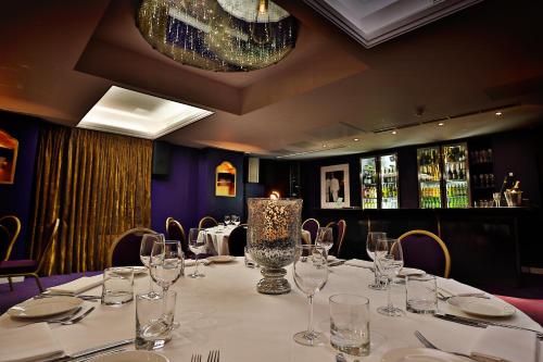 a dining room with a table with wine glasses at Karma Sanctum Soho Hotel in London