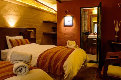 a bedroom with two beds and a bathroom with a sink at Hotel Jardines de Uyuni in Uyuni