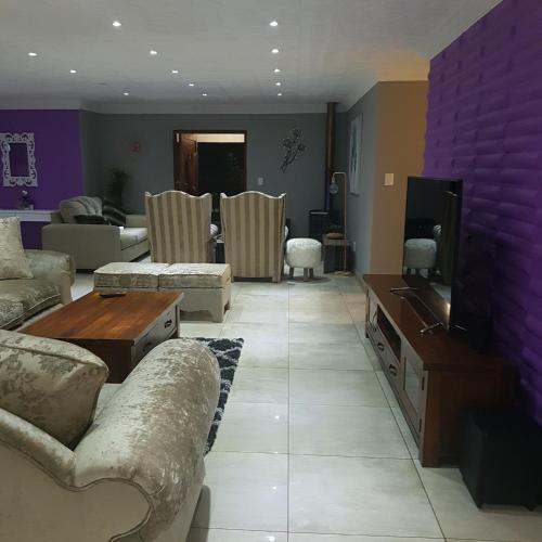 a living room with a couch and a tv at Dinaledi House in Bela-Bela