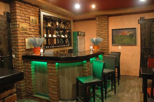 a bar in a restaurant with green lighting at Гостинний Двір in Lviv