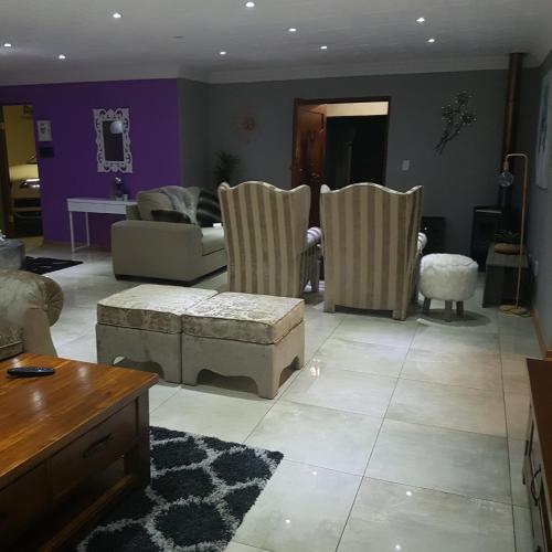 a living room with a couch and chairs at Dinaledi House in Bela-Bela
