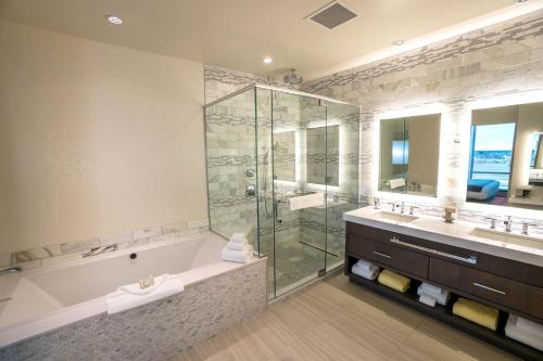 un baño con bañera y ducha de cristal en Rhythm City Casino & Resort, en Davenport