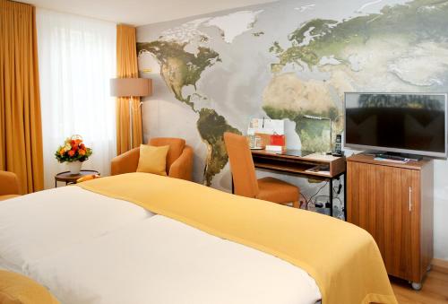 Schlafzimmer mit einem Bett und einem Schreibtisch mit einem TV in der Unterkunft Hotel Am Schloss *** Superior in Tübingen