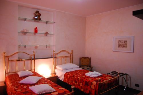a bedroom with two beds and a lamp at Casa MaMa Guesthouse in Genova