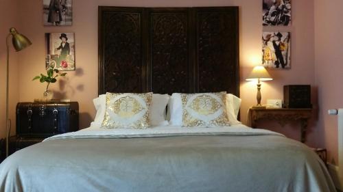 a bedroom with a large bed with white sheets and pillows at Casona Del Duende in Alájar