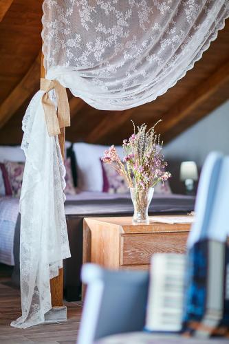 a dress and a vase of flowers on a table at Archodiko Toliadi Boutique Apartments and Suites in Ouranoupoli