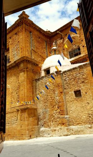 a brick building with blue and yellow flags on it at Borgo Saraceno in Sambuca di Sicilia