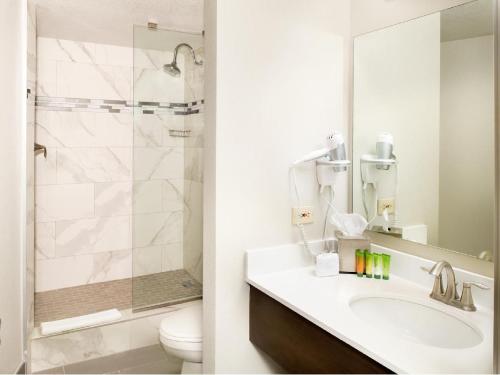 a bathroom with a sink and a toilet and a mirror at The STRAT Hotel, Casino & Tower in Las Vegas