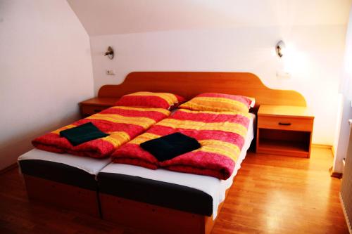 uma cama com um cobertor colorido num quarto em Favilla üdülőház em Bogács