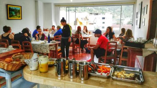 a group of people sitting at tables in a restaurant at Napolitano Apart Hotel in Baños