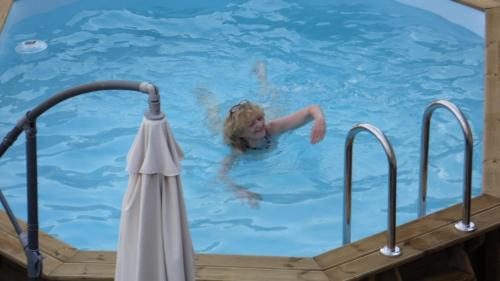 Eine Frau, die im Schwimmbad schwimmt. in der Unterkunft Maison le trèfle in Chef-Boutonne