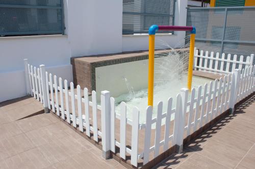 a pool of water in a white fence at Deluxe Hostels & Suites Merida in Merida