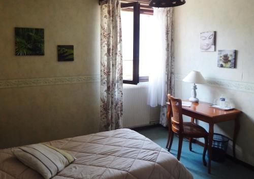 1 dormitorio con cama, escritorio y ventana en Hotel Restaurant Le Cygne, en Conches-en-Ouche