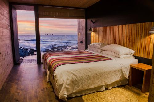 a bedroom with a bed with a view of the ocean at Hotel Apacheta in Arica