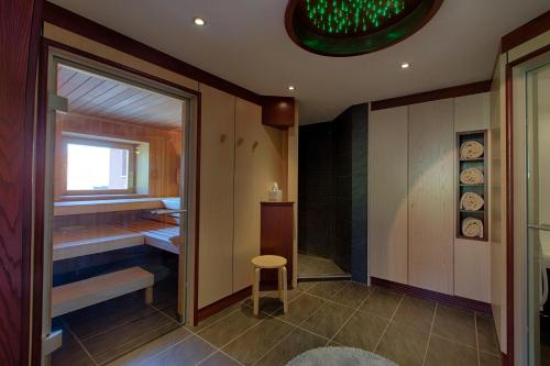 a bathroom with a shower and a stool in a room at Hotel Restaurant des Vosges in Birkenwald