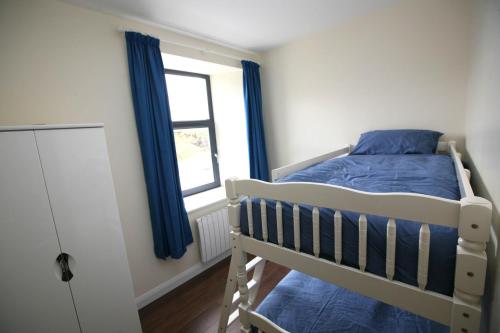 um quarto com um beliche e uma janela em Harbour front apartments em Burtonport
