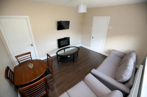 a living room with a couch and a table at Harbour front apartments in Burtonport