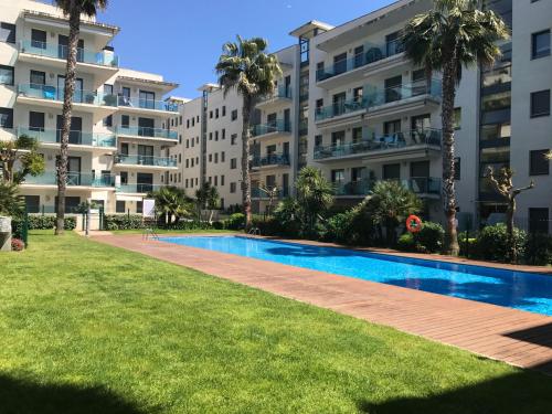 a swimming pool in front of some apartment buildings at Apartamentos Jardín Turquesa in Lloret de Mar