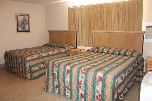 a hotel room with two beds and a window at Stagecoach Motel in Grass Valley