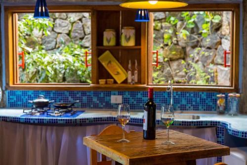 dos copas de vino en una mesa en una cocina en Sea View Colorful House, en Ilhabela