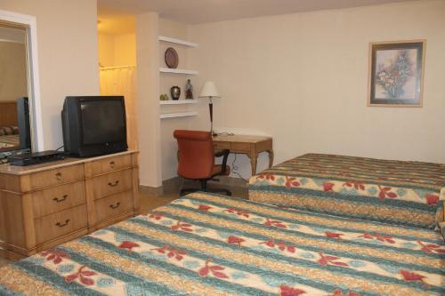 a hotel room with two beds and a television at Stagecoach Motel in Grass Valley