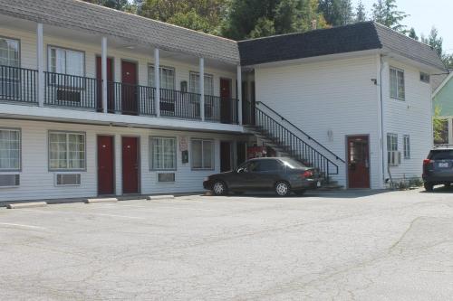 un coche aparcado frente a un edificio en Stagecoach Motel, en Grass Valley