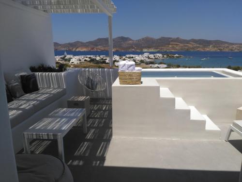 a patio with a couch and a swimming pool at Milos Breeze Boutique Hotel in Pollonia