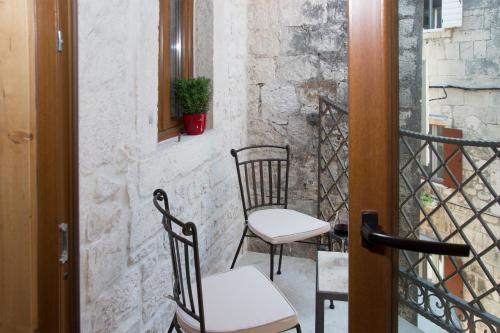 a pair of chairs sitting on a balcony at Villa Kudelik - Stone Story in Trogir