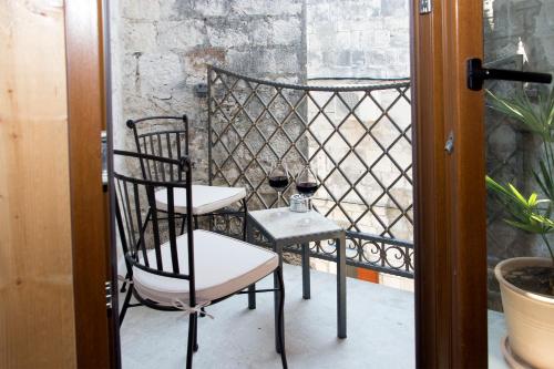 two chairs and a table on a balcony at Villa Kudelik - Stone Story in Trogir